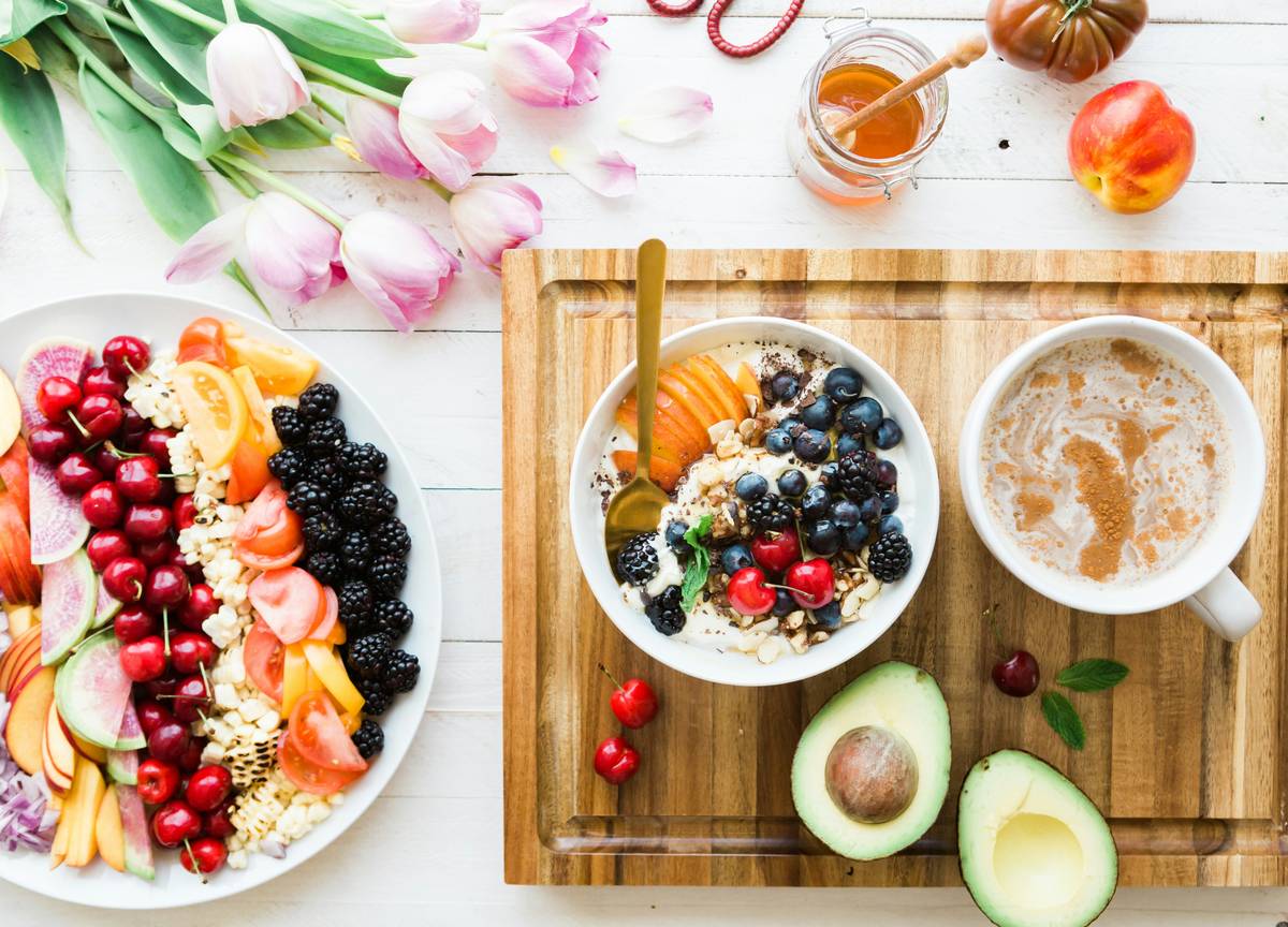 how to reduce gut inflammation diet with colorful anti-inflammatory foods like leafy greens, berries, and salmon on a white plate